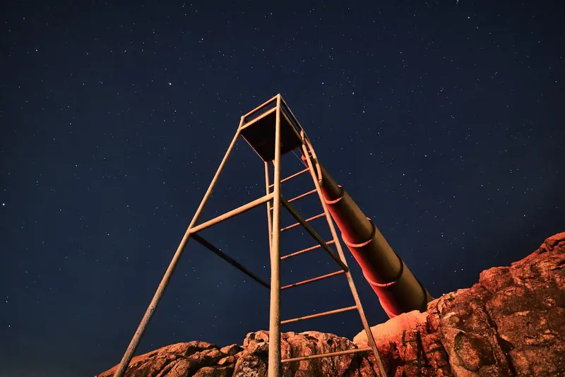Low-angle view of a stargazing tower against a clear starry night sky, ideal for astronomy enthusiasts
