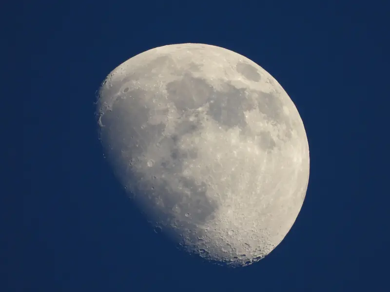 High-resolution capture of the moon showcasing craters and surface detail against a vibrant night sky