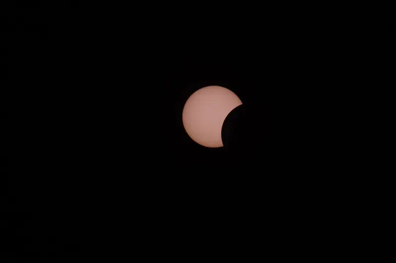 A captivating partial solar eclipse captured against a dark night sky, showcasing celestial wonder