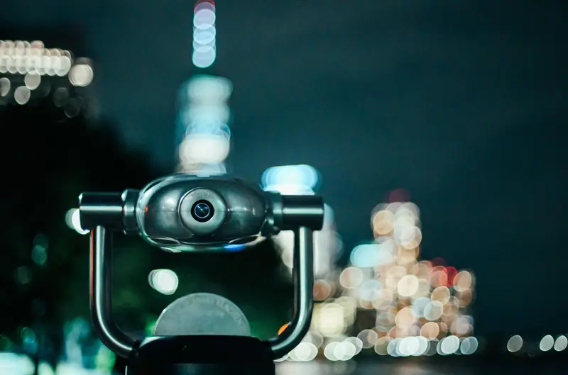 Coin operated binoculars capturing bokeh-lit New York City at night