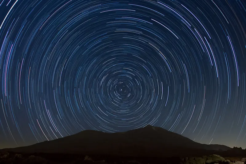 Long exposure of star trails over Mount Teide, capturing the night sky's celestial beauty